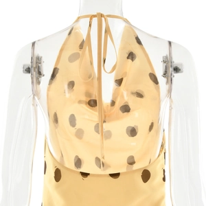 Detail of yellow polka dot dress with backless halter neck on mannequin