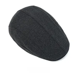 Top view of dark grey herringbone newsboy cap showing thick tweed texture and fabric detail