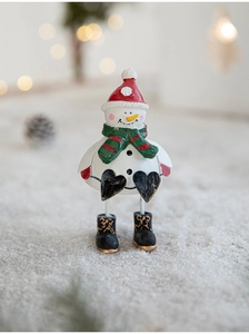 Macro detail of a cute snowman figurine with red hat and scarf for Christmas decor