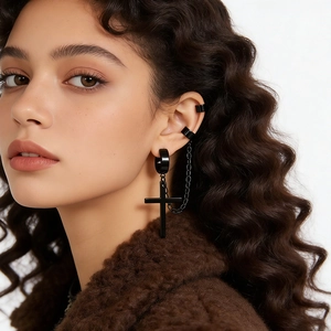 Detailed view of black titanium cross chain earring with ear cuff on model's ear