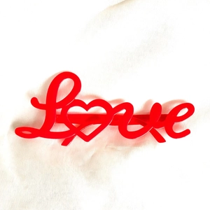 Red Love letter heart hair clip on white textured fabric background for Valentines Day