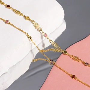 Macro view of gold-plated copper necklace with colorful zircon stones and mirror reflection