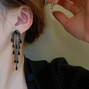 Gros plan de boucles d'oreilles pendantes à pampilles en zircon noir sur un mannequin