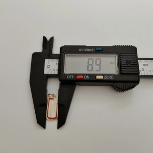 Detail view showing a 8.9mm Merry Christmas pendant length measured with digital calipers