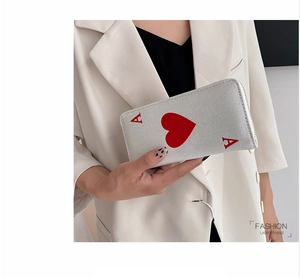 Close-up of Ace of Hearts pattern on fashion canvas clutch bag held by model