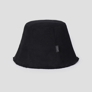 Detail of black corduroy bucket hat featuring frayed tassel edges and textured vertical stripes