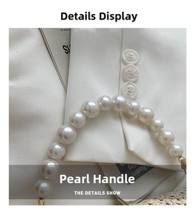 Detail of elegant pearl handle with gold metallic hardware on a summer straw bag