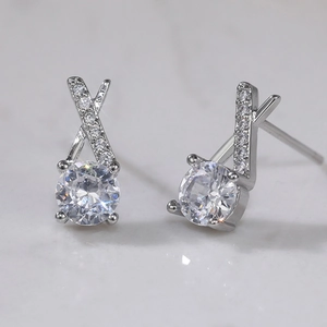 Macro shot of silver plated cross stud earrings featuring brilliant round zircon stones