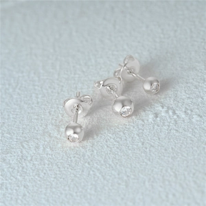 Macro shot of three S925 sterling silver stud earrings with round cubic zirconia and butterfly backs