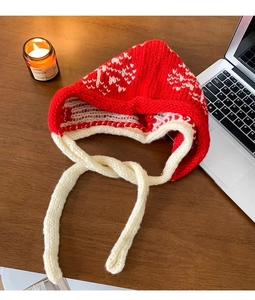 Detail of red and white handmade crochet knit balaclava with earflaps and long ties
