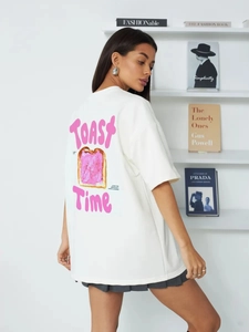 Λεπτομέρεια του ροζ Toast Time τύπωμα στην πλάτη του λευκού βαμβακερού oversized T-shirt