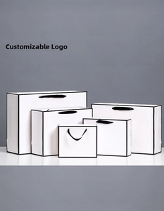 Detail of minimalist white gift bags with black edges in various sizes and ribbon handles