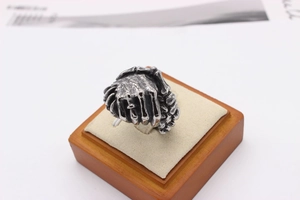 Macro shot of retro steel handshake ring with distressed black finish on display stand