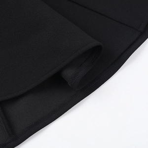 Close-up of black dress fabric showing premium textured weave and precise hem stitching