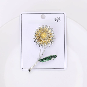 Détail de la broche pissenlit avec feuilles d'émail vert sur assiette céramique