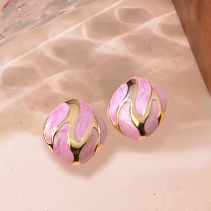 Macro shot of pink enamel irregular square earrings with golden streamlined metal frames