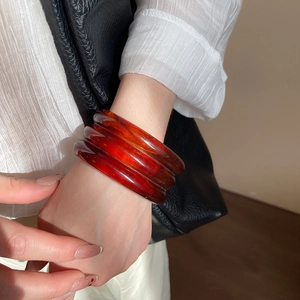 Close-up of minimalist amber resin triple-layered bangles with geometric textures