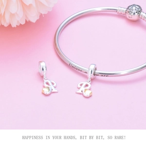 Detail of S925 sterling silver snake chain bracelet with letter R charms and gold hearts