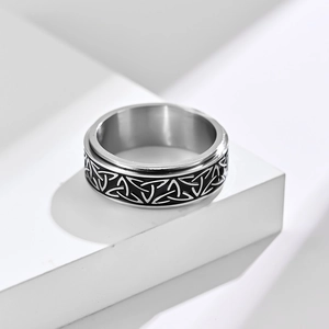 Rotating stainless steel Celtic knot ring in silver and black on a white platform