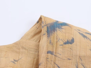 Detail of ginger tie-dye pleated fabric showing crinkled texture and sewing craftsmanship