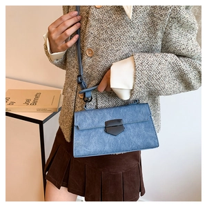 Detailed view of the blue stone pattern texture and metallic buckle on a crossbody bag