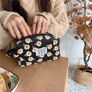 Gros plan sur la trousse à maquillage en velours côtelé avec motif floral et étiquette