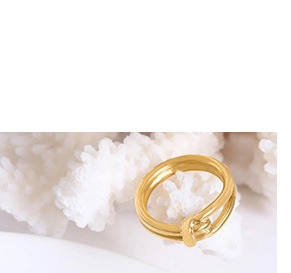 Detail of minimalist 18K gold plated double-loop ring on white coral display