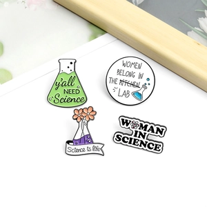 Lot de quatre pin's en émail coloré sur le thème de la science sur fond blanc