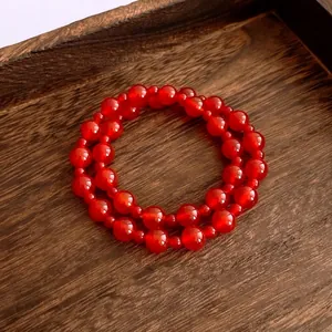 Vintage red agate beaded bracelet with polished double-layer design on dark wooden tray