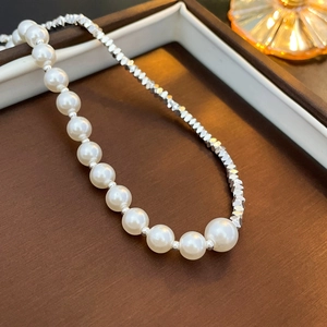 Macro shot of elegant white pearls and faceted silver metallic beads on a luxury jewelry tray