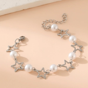 Silver stainless steel bracelet with star pendants and imitation pearls on peach background