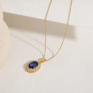 Detailed macro view of the oval blue gemstone pendant with sparkling zircon accents