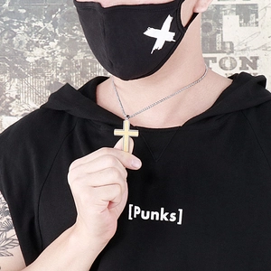Macro detail of two-tone steel cross pendant with frosted finish on male model