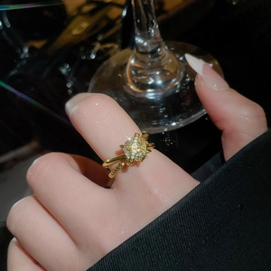 Macro detail of a crisscross gold ring with sparkling cubic zirconia on a model finger