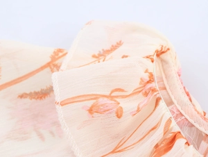 Nahaufnahme von Chiffonstoff mit Blumenmuster, Rüschensaum und feinen Nähten
