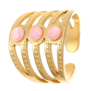 Détail d'une bague multicouche dorée avec reliefs à pois et pierres cabochons roses