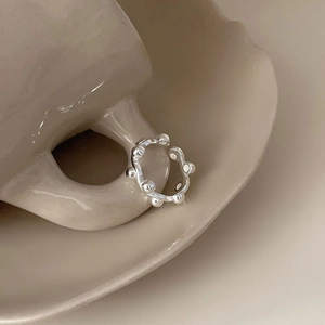 Adjustable 925 sterling silver beaded bubble ring hanging on a ceramic cup handle
