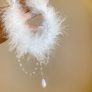 Detail of double-layer pearl necklace featuring soft white feathers and crystal tassel fringe