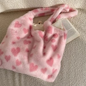 Detail of plush pink tote bag showing soft faux fur, red heart patterns and magnetic closure