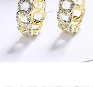 Macro detail of S925 sterling silver stamp on gold plated chain earrings with cubic zirconia