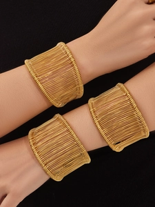 Vue détaillée de trois bracelets joncs larges enroulés de fil plaqué or 18 carats