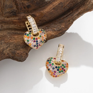 Golden heart earrings with rainbow pavé zircons and crystal hoops on natural wood