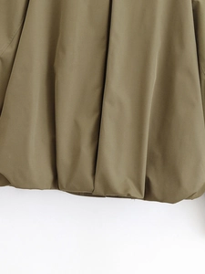 Detailed macro view of olive green bomber jacket hem with elastic pleated texture