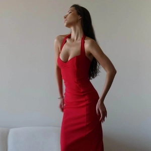 Detail of red halter neck dress showing the slim fit silhouette and thigh high side slit