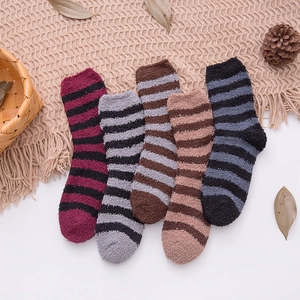 Flat lay of five pairs of striped coral fleece socks for men in various warm colors