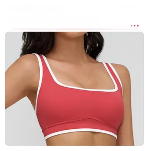 Detail of red square neck sports bra with white trim and removable pads for yoga