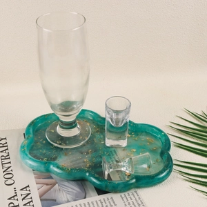 Detailed view of cloud-shaped emerald green resin tray with embedded gold foil flakes