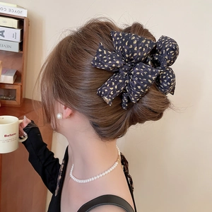 Elegant large leopard print bow claw clip styled on a classic French bun hair updo
