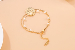 Close-up of double-layer stainless steel gold bracelet with star coin and pearls