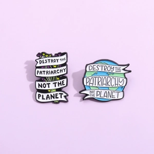 Creative enamel pins with Destroy The Patriarchy and Not The Planet slogans on lilac base